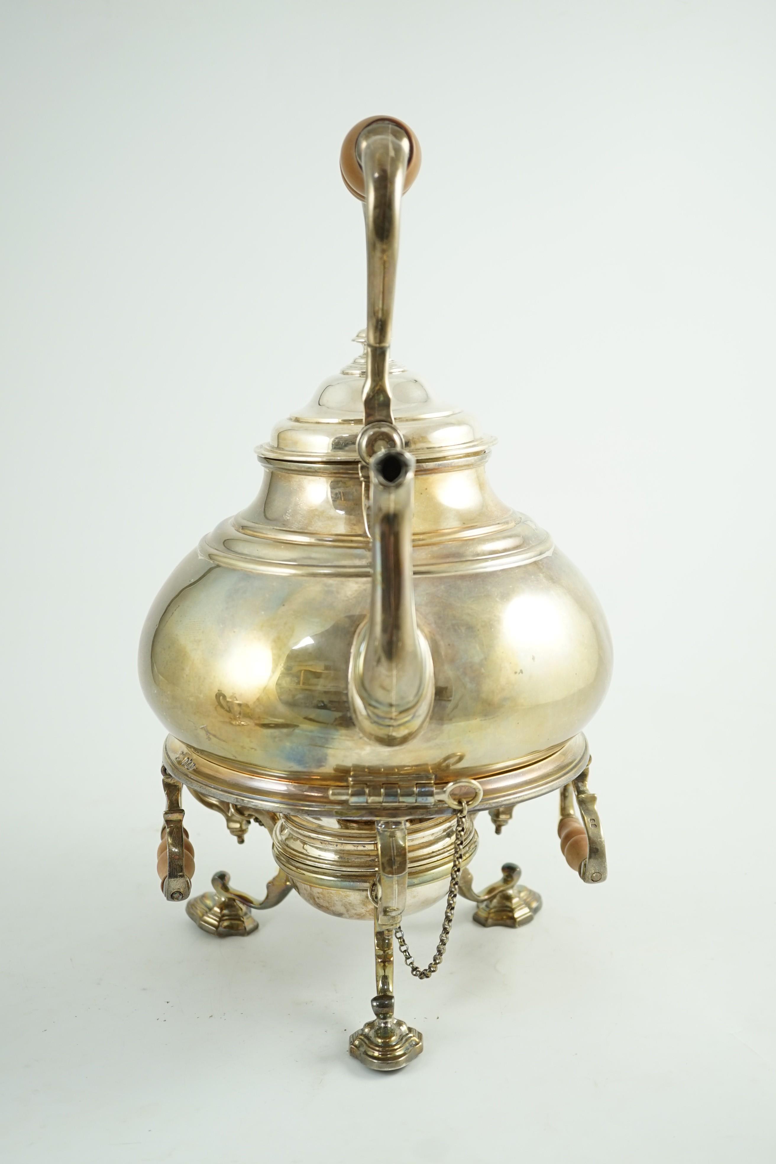 A large George V Britannia standard silver tea kettle on two handled stand, with burner, by Charles & Richard Comyns